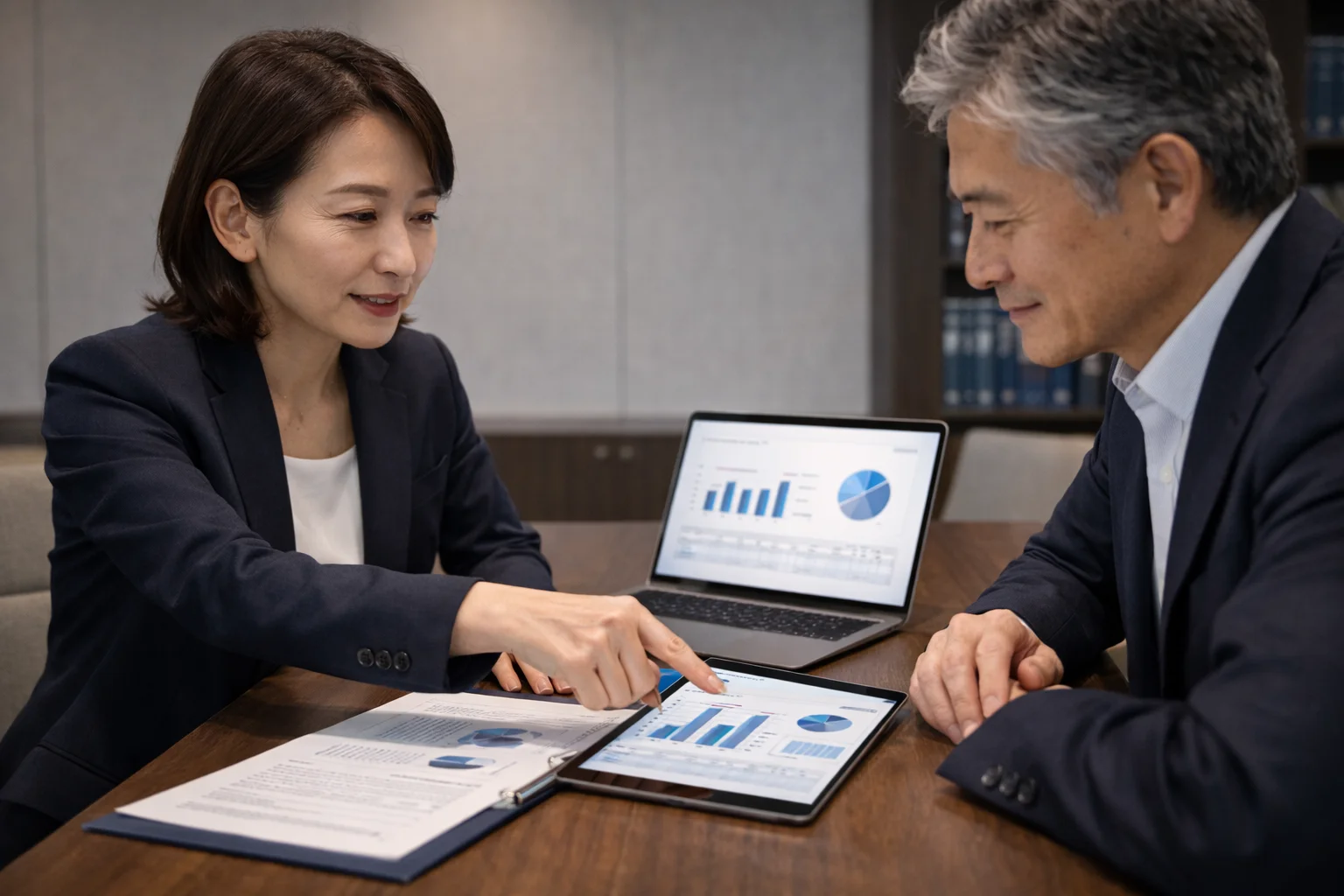 企業価値評価の資料とグラフを確認している日本人経営者と専門家のシーン