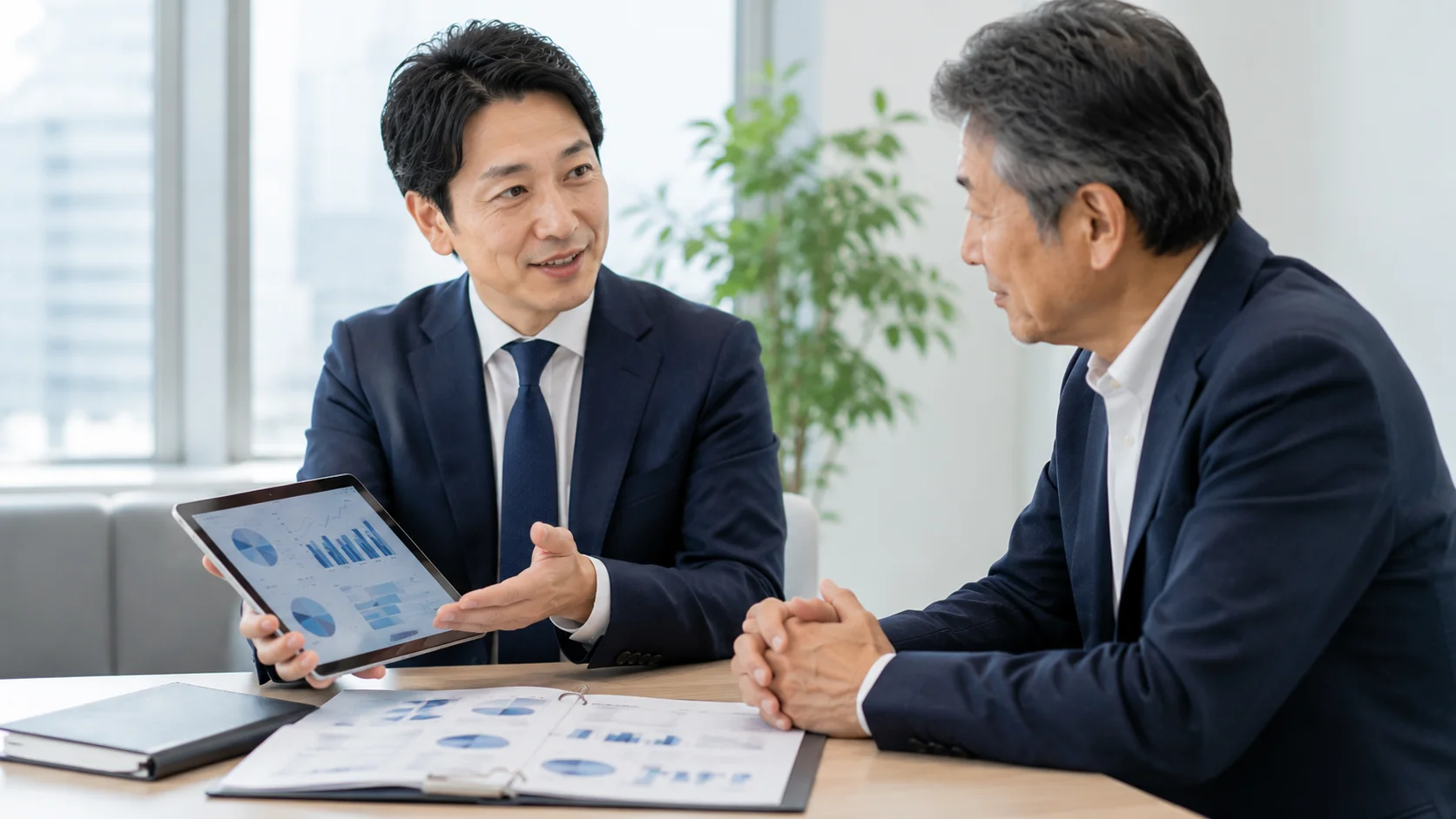 M&Aの基礎知識を日本人アドバイザーがタブレット資料を使って経営者にわかりやすく説明する様子