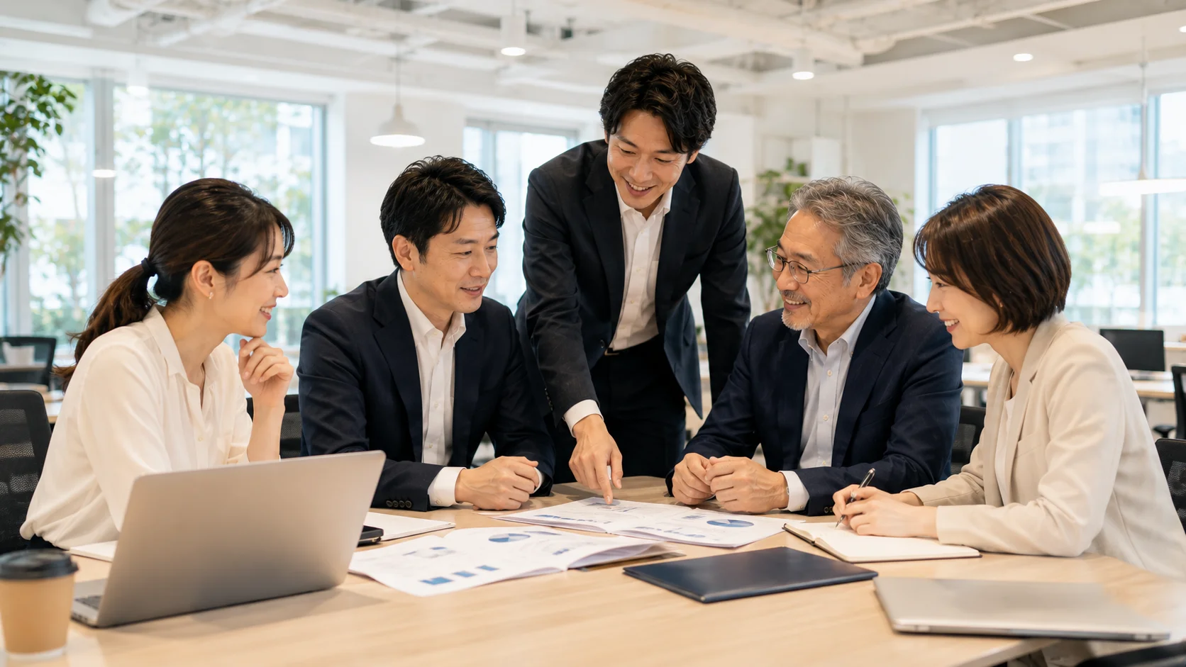 M&A成立後のPMIで日本人の少人数チームが明るいオフィスで前向きに協力し合う様子