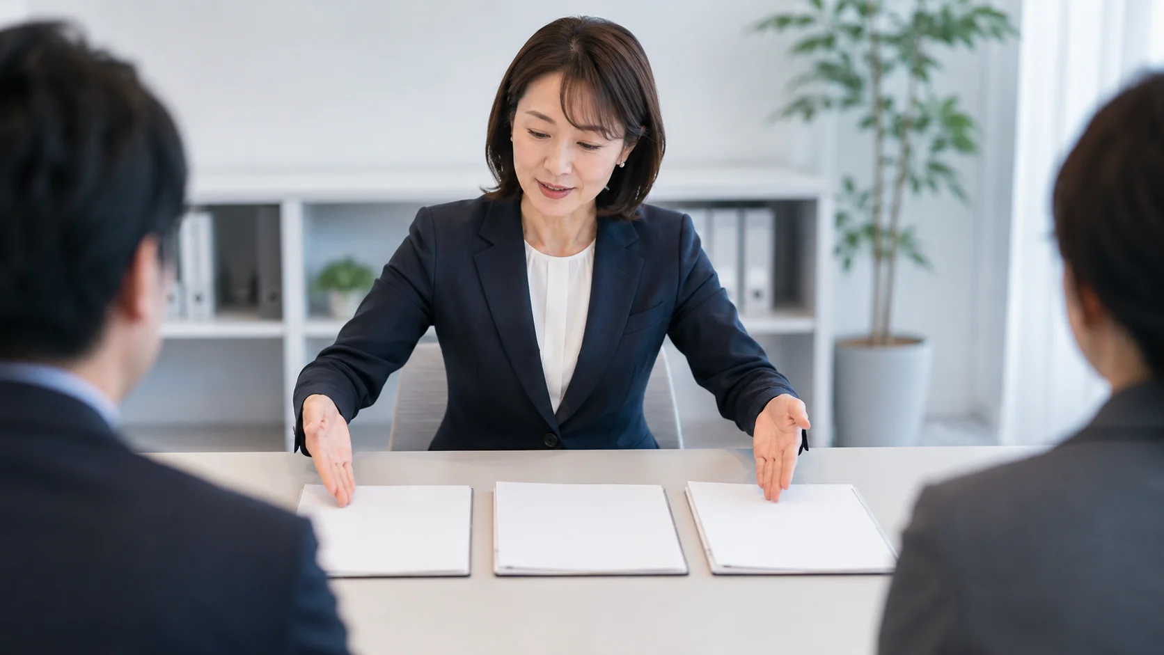 複数の書類や契約書類を並べて手法を比較検討する経営者のビジネスシーン